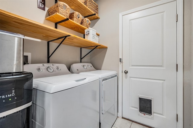 laundry room featuring washing machine and dryer and light tile patterned flooring