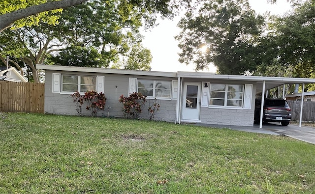 manufactured / mobile home featuring a front yard and a carport