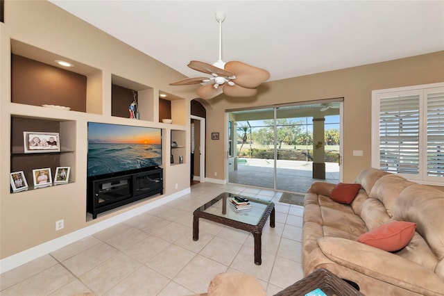 living room featuring built in shelves, ceiling fan, and light tile patterned floors