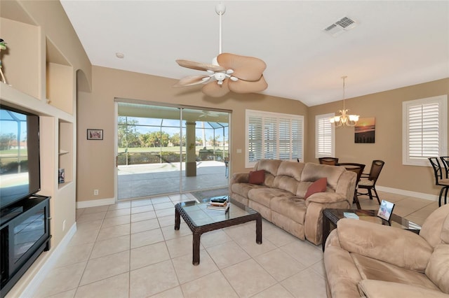 tiled living room featuring plenty of natural light and ceiling fan with notable chandelier