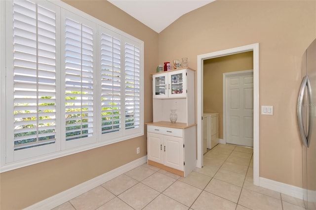616 Misty Pond Ct, Bradenton, FL 34212 - dining area with light tile patterned flooring, vaulted ceiling, washing machine and clothes dryer, and arched walkways