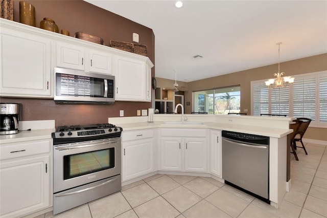 kitchen featuring white cabinets, a notable chandelier, kitchen peninsula, and stainless steel appliances