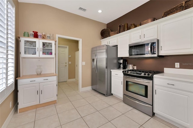 616 Misty Pond Ct, Bradenton, FL 34212 - kitchen with stainless steel appliances, light countertops, white cabinets, light tile patterned flooring, and glass insert cabinets