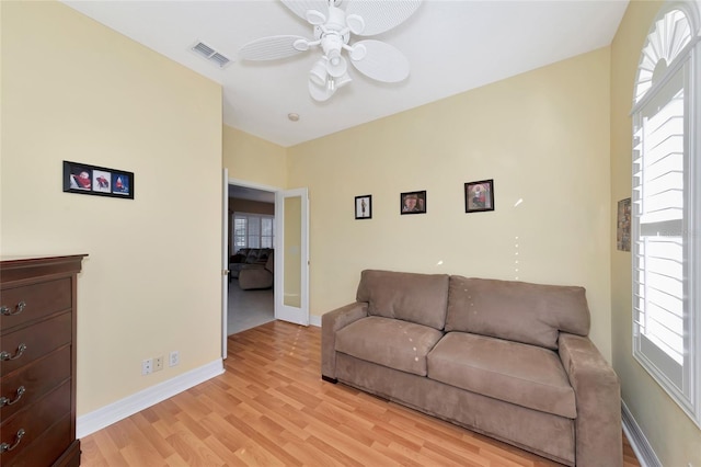 living room with a wealth of natural light, ceiling fan, and light wood-type flooring