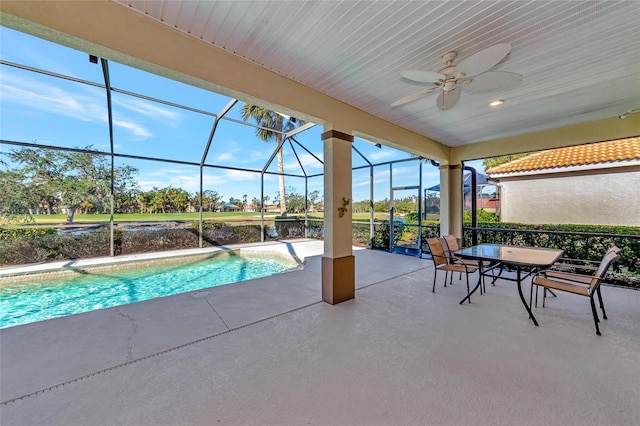 view of swimming pool with ceiling fan, a lanai, and a patio