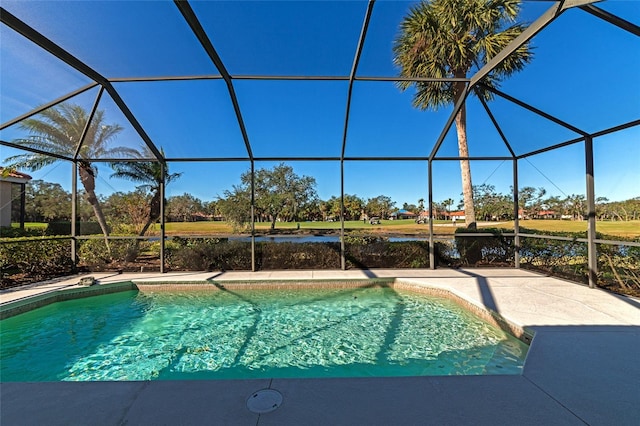 view of swimming pool featuring glass enclosure and a water view