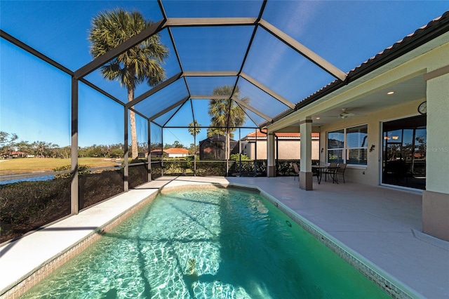 view of swimming pool featuring ceiling fan, a lanai, and a patio