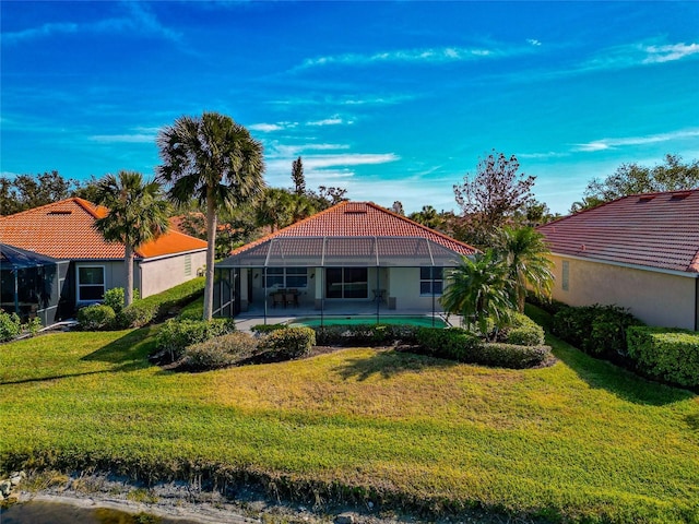 back of house featuring a lawn and a lanai