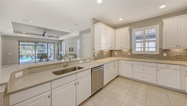 kitchen featuring tasteful backsplash, ceiling fan, sink, dishwasher, and white cabinetry