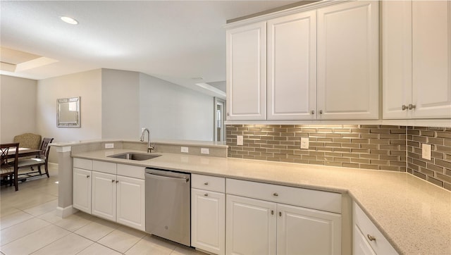 kitchen with dishwasher, backsplash, white cabinets, sink, and light tile patterned flooring