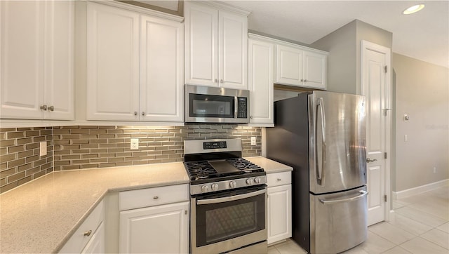 kitchen with backsplash, white cabinetry, light tile patterned flooring, and stainless steel appliances