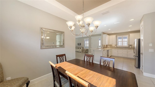 dining space featuring sink, light tile patterned flooring, and a chandelier