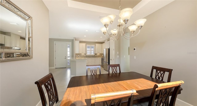 tiled dining room with an inviting chandelier