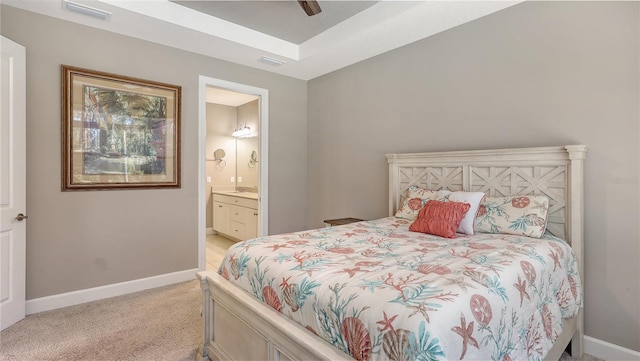 carpeted bedroom featuring ceiling fan and ensuite bath