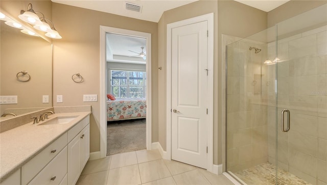 bathroom with tile patterned floors, ceiling fan, an enclosed shower, and vanity