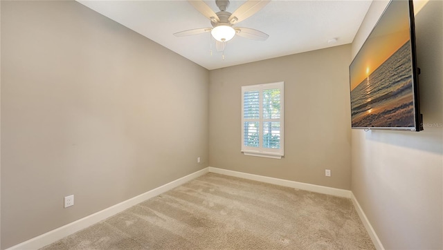 spare room featuring light carpet and ceiling fan