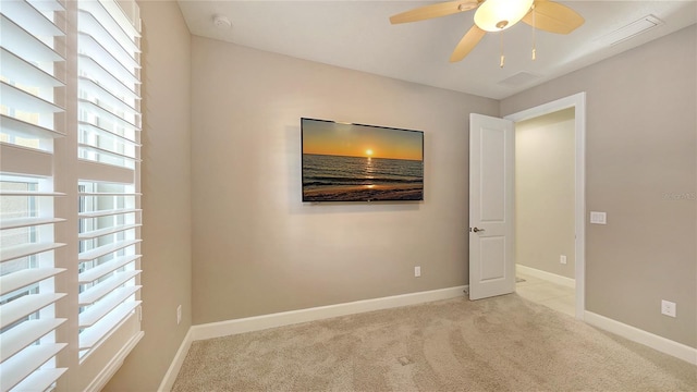 spare room with ceiling fan and light carpet