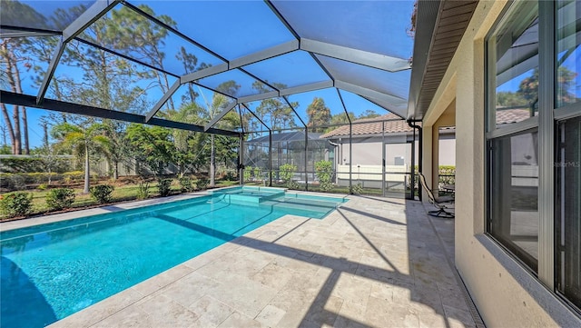 view of pool featuring glass enclosure and a patio