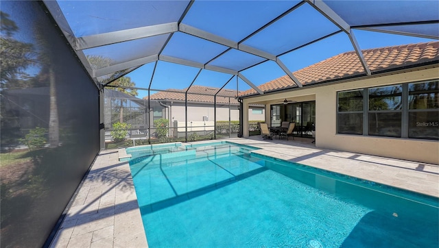 view of pool with ceiling fan, a patio, and glass enclosure