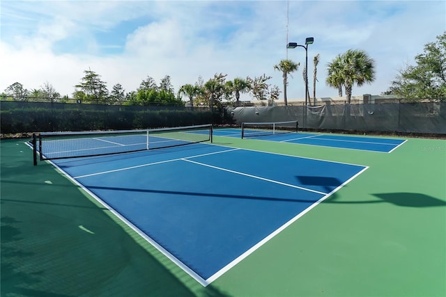 view of tennis court with basketball hoop