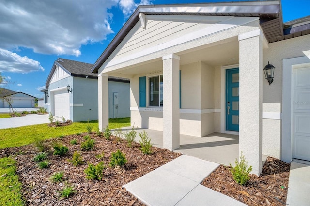 view of exterior entry featuring a garage and covered porch