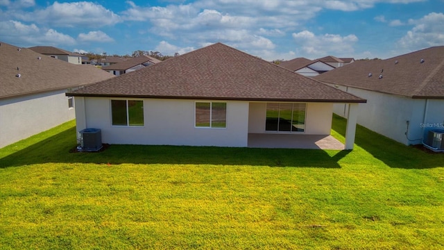 back of house featuring cooling unit, a yard, and a patio