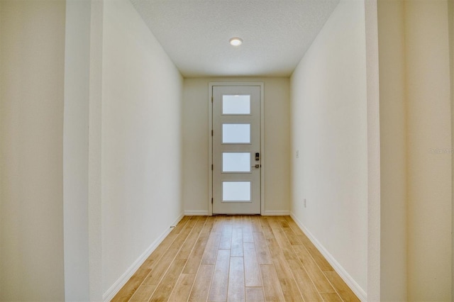 entryway with a textured ceiling and light wood-type flooring