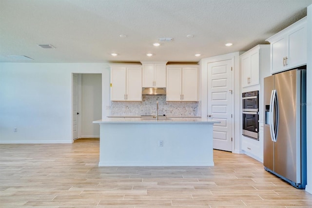 kitchen with a center island with sink, white cabinetry, appliances with stainless steel finishes, and light hardwood / wood-style flooring