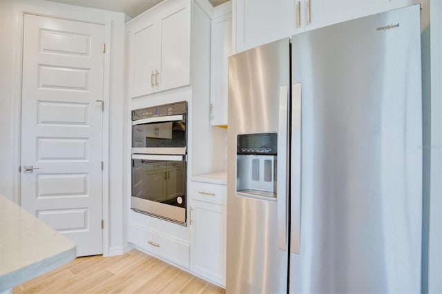 kitchen featuring white cabinetry, light hardwood / wood-style flooring, and appliances with stainless steel finishes