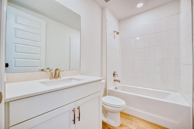 full bathroom with wood-type flooring, vanity, toilet, and tiled shower / bath