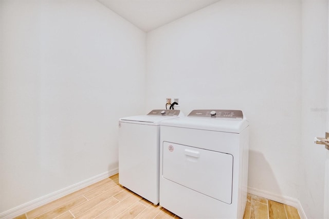 washroom featuring washer and clothes dryer and light hardwood / wood-style flooring