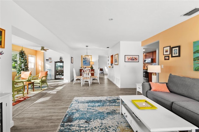 living room with dark hardwood / wood-style floors and ceiling fan