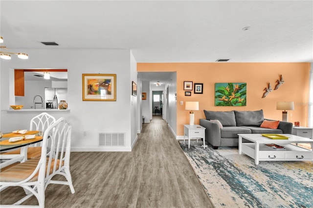 living room featuring ceiling fan, hardwood / wood-style floors, and sink