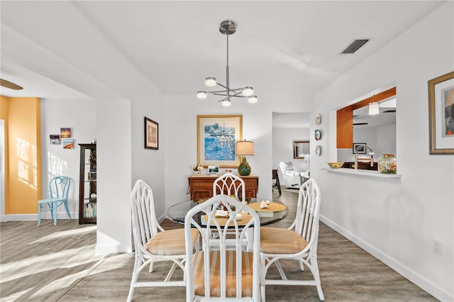 dining room featuring hardwood / wood-style floors and a chandelier