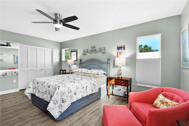 bedroom featuring a closet, hardwood / wood-style flooring, multiple windows, and ceiling fan