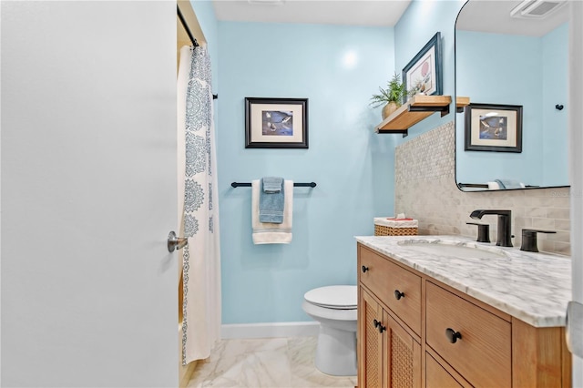 bathroom featuring tile patterned floors, vanity, toilet, and tasteful backsplash