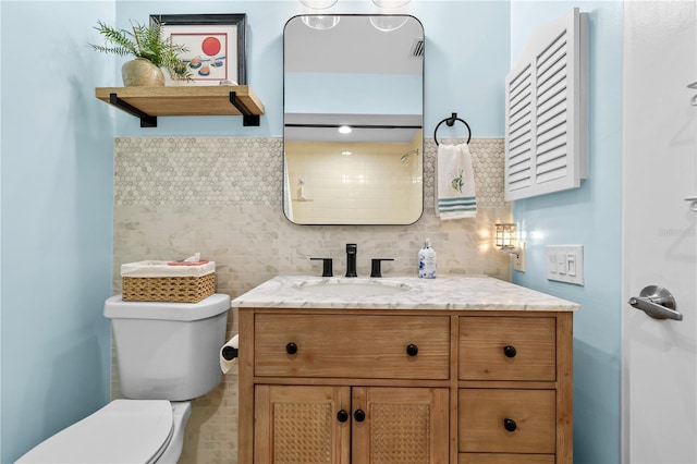 bathroom with decorative backsplash, vanity, and toilet