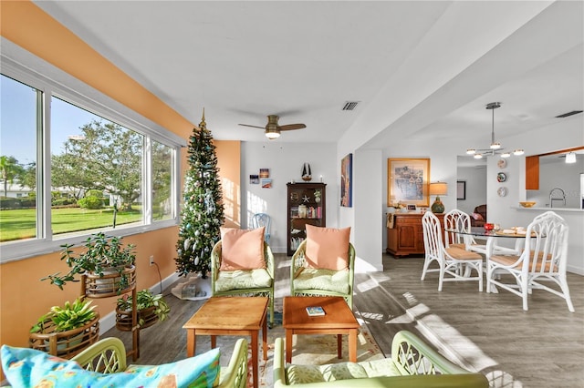 living room featuring dark hardwood / wood-style floors, ceiling fan, and sink