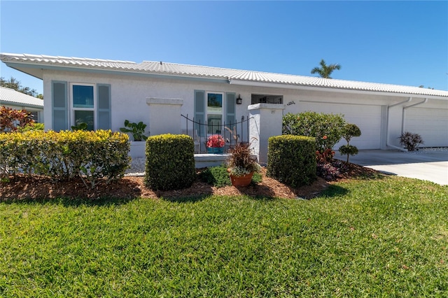 ranch-style house with stucco siding, an attached garage, and a front lawn