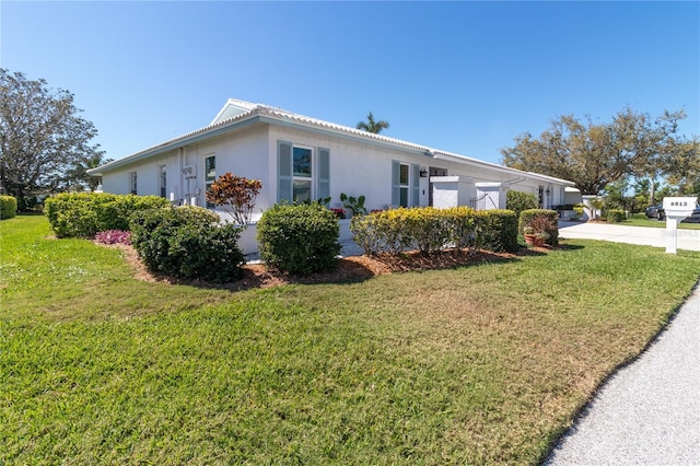 view of property exterior with a yard, a garage, concrete driveway, and stucco siding