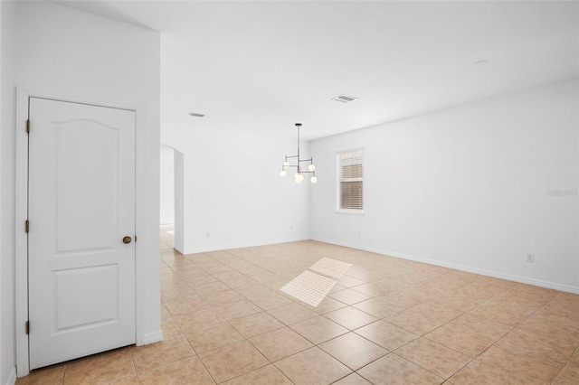 empty room featuring light tile patterned floors and an inviting chandelier