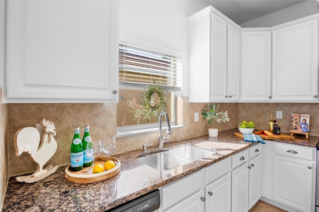 kitchen featuring dark stone countertops, sink, and white cabinets