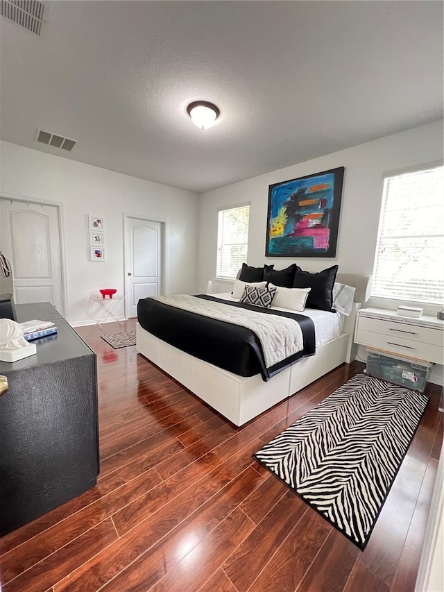 bedroom with dark hardwood / wood-style flooring