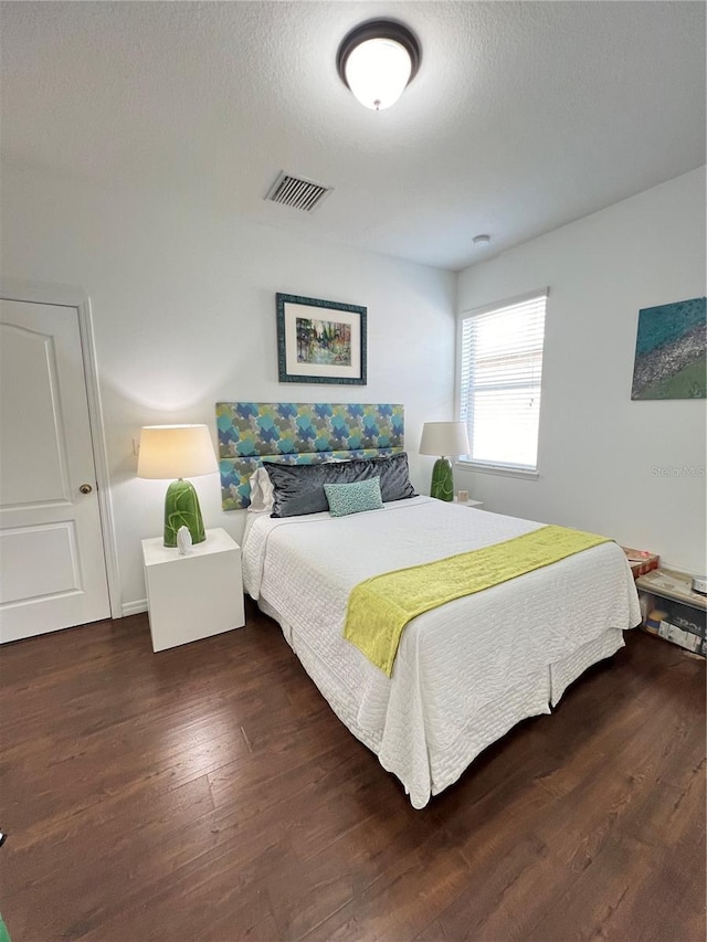 bedroom featuring dark hardwood / wood-style floors and a textured ceiling