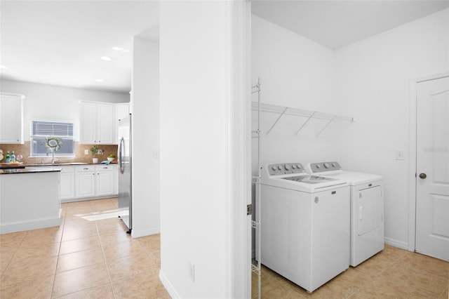 washroom with light tile patterned flooring, independent washer and dryer, and sink