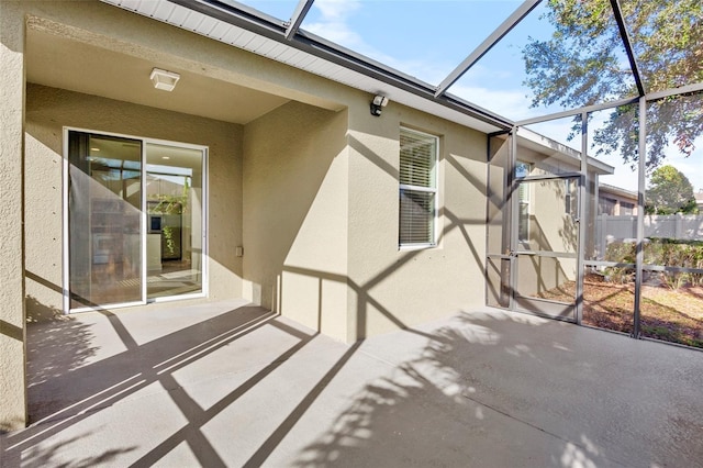 view of patio featuring glass enclosure