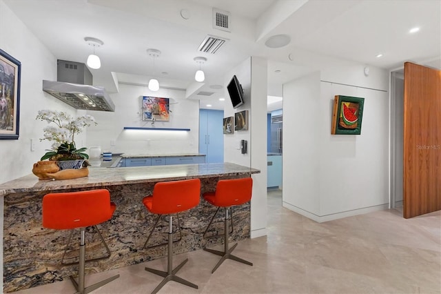 kitchen featuring pendant lighting, exhaust hood, kitchen peninsula, and a kitchen bar