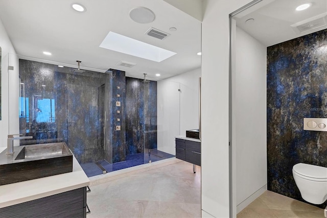 bathroom with toilet, a tile shower, vanity, and a skylight