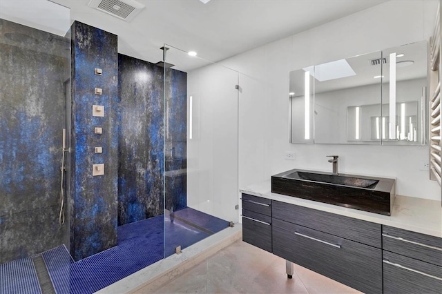 bathroom featuring vanity, tile patterned flooring, and a tile shower