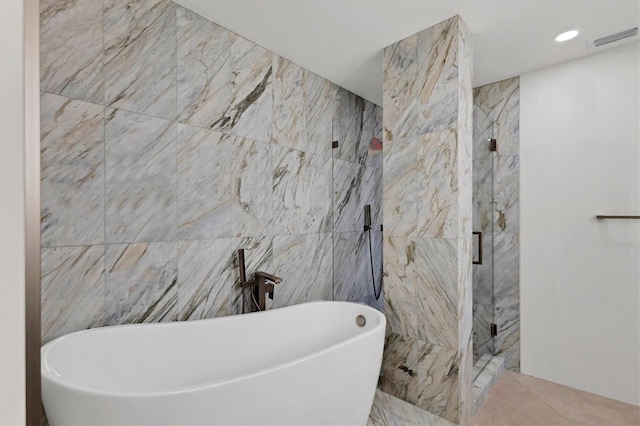 bathroom featuring plus walk in shower and tile walls